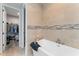 Elegant bathroom with a soaking tub and tiled walls, next to the walk-in closet at 4142 N Nebraska Ave, Tampa, FL 33603
