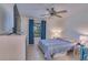 Cozy bedroom with a queen-size bed, a ceiling fan, a TV, a dresser, and a window with blue curtains at 4215 E Bay Dr # 105, Clearwater, FL 33764