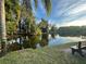 Scenic view of a tranquil pond with lush landscaping, a bench, and clear water at 4215 E Bay Dr # 105, Clearwater, FL 33764