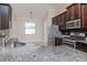 A view of the kitchen featuring granite countertops, stainless steel appliances and dark wood cabinetry at 8419 May Port Ct, Land O Lakes, FL 34638