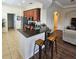 Kitchen with wooden cabinets, stainless steel appliances, and a breakfast bar with seating, all in a flowing floorplan at 920 Regal Manor Way, Sun City Center, FL 33573