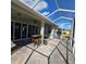 Screened patio with bar-style table and chairs overlooking the manicured backyard and blue sky on a sunny day at 920 Regal Manor Way, Sun City Center, FL 33573