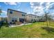 A spacious backyard featuring a grassy area, patio with outdoor seating, and a full fence around the property at 12515 Horseshoe Bend Dr, Lithia, FL 33547