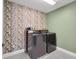 Modern laundry room with gray appliances, floral wallpaper, and sleek design at 12515 Horseshoe Bend Dr, Lithia, FL 33547