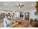 Open-concept living room with wood flooring, modern ceiling fan, and bright, neutral colors at 12515 Horseshoe Bend Dr, Lithia, FL 33547