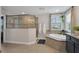 Well-lit bathroom featuring a glass shower, soaking tub, and stylish vanity at 12515 Horseshoe Bend Dr, Lithia, FL 33547