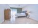 Bright bedroom featuring light tile floors, neutral walls, stylish dresser and bedside table at 1655 S Highland Ave # B110, Clearwater, FL 33756