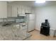 Bright kitchen with granite countertops, white appliances, and ample cabinet space at 1655 S Highland Ave # B110, Clearwater, FL 33756