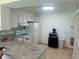 Efficient kitchen featuring granite countertops, white cabinetry, and modern appliances at 1655 S Highland Ave # B110, Clearwater, FL 33756