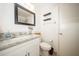 Bathroom featuring a granite countertop, single sink, framed mirror and decorative shelves at 5100 Burchette Rd # 306, Tampa, FL 33647
