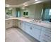 Bathroom with double sinks, white cabinets, and marble floors at 6315 Shoreline Dr # 3204, Seminole, FL 33708