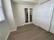 View of a bedroom with wood-look flooring, leading to a mirrored door and a closet at 6315 Shoreline Dr # 3204, Seminole, FL 33708