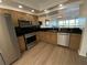 Modern kitchen with stainless steel appliances, black countertops, wood cabinets, and updated flooring at 6315 Shoreline Dr # 3204, Seminole, FL 33708