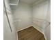 Spacious walk-in closet featuring custom wire shelving units and modern wood-look flooring at 6315 Shoreline Dr # 3204, Seminole, FL 33708