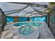 Large pool and spa with screen enclosure, next to a vibrant home exterior at 6560 5Th S Ave, St Petersburg, FL 33707