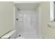 Close-up of a shower and toilet with white tiles at 1370 70Th N St # 2-1382, St Petersburg, FL 33710