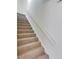 Carpeted staircase with white handrail against a light gray wall leading upstairs inside the apartment building at 1370 70Th N St # 2-1382, St Petersburg, FL 33710