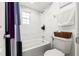 Bathroom featuring a bathtub with shower, white marble tile, and modern fixtures at 16109 Northglenn Dr, Tampa, FL 33618