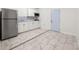 Efficient kitchen with stainless steel appliances, white cabinets, and a light blue door at 16109 Northglenn Dr, Tampa, FL 33618
