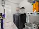 Functional laundry room with a modern washer and dryer, shelves for storage and marble flooring at 16109 Northglenn Dr, Tampa, FL 33618