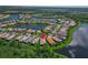 Aerial view of a charming home nestled by a lake in a residential area at 16135 Cape Coral Dr, Wimauma, FL 33598
