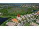 Aerial view of home highlighting lush surroundings and nearby lakes at 16135 Cape Coral Dr, Wimauma, FL 33598