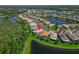 Beautiful aerial view of a home with a pool surrounded by a lake and lush landscaping in a gated community at 16135 Cape Coral Dr, Wimauma, FL 33598