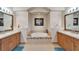 Modern bathroom with double sinks, a jacuzzi tub, and neutral tile at 16135 Cape Coral Dr, Wimauma, FL 33598