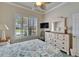 Cozy bedroom featuring a palm-leaf ceiling fan and plantation shutters for natural light control at 16135 Cape Coral Dr, Wimauma, FL 33598