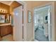 Hallway view into bedroom with bathroom, featuring natural light and a peaceful color palette at 16135 Cape Coral Dr, Wimauma, FL 33598