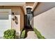 Charming front entrance featuring a decorative security door, stone walkway, and elegant exterior lighting at 16135 Cape Coral Dr, Wimauma, FL 33598