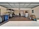 Spacious garage with epoxy flooring, overhead storage racks, and ample room for parking and storage at 16135 Cape Coral Dr, Wimauma, FL 33598