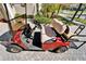 Close-up of a red golf cart showing seating and controls, perfect for enjoying community amenities at 16135 Cape Coral Dr, Wimauma, FL 33598