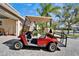 Red golf cart parked next to the house, providing easy access and enjoyment of community amenities at 16135 Cape Coral Dr, Wimauma, FL 33598