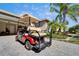 Pictured is the golf cart included with the home, sitting on a brick paved driveway at 16135 Cape Coral Dr, Wimauma, FL 33598