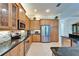 Modern kitchen featuring stainless steel appliances, granite countertops, custom cabinets, and tile backsplash at 16135 Cape Coral Dr, Wimauma, FL 33598