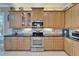 Stunning kitchen boasts stainless steel appliances, beautiful cabinetry, granite counters, and tile backsplash at 16135 Cape Coral Dr, Wimauma, FL 33598