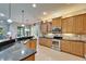 Well-equipped kitchen featuring granite countertops, stainless appliances, custom cabinets, and tile flooring at 16135 Cape Coral Dr, Wimauma, FL 33598