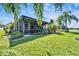 Inviting screened-in lanai surrounded by lush greenery, offering a peaceful retreat with beautiful landscaping at 16135 Cape Coral Dr, Wimauma, FL 33598