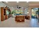 Spacious living room boasting ample natural light, tile floors, and seamless access to the screened lanai at 16135 Cape Coral Dr, Wimauma, FL 33598