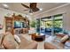Comfortable living room with stylish furnishings, large windows offering pleasant outdoor views, and a ceiling fan at 16135 Cape Coral Dr, Wimauma, FL 33598