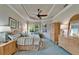 Serene main bedroom showcases large windows, a tray ceiling with fan, and a cozy sitting area at 16135 Cape Coral Dr, Wimauma, FL 33598