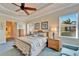 Bright, airy main bedroom featuring a tray ceiling, ceiling fan, and a light, neutral color palette at 16135 Cape Coral Dr, Wimauma, FL 33598