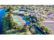 Aerial shot featuring community pickleball courts adjacent to tennis courts and lush greenery at 16135 Cape Coral Dr, Wimauma, FL 33598