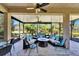 Relaxing screened lanai featuring comfortable seating, ceiling fans, and views of the lush landscaping at 16135 Cape Coral Dr, Wimauma, FL 33598