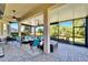 Spacious screened-in lanai showcasing outdoor seating, a ceiling fan, and beautiful views of the surrounding landscape at 16135 Cape Coral Dr, Wimauma, FL 33598