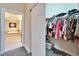 Walk-in closet with organized storage; primary bathroom with tub in the background at 16135 Cape Coral Dr, Wimauma, FL 33598
