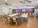 Large meeting room with tile floor, folding tables, and chairs, and a billiard table with colorful wall art at 24862 Us Highway 19 N # 3001, Clearwater, FL 33763