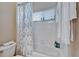 Bright bathroom featuring a shower-tub combo, white tile, and a window for natural light at 2903 Marble Crest Dr, Land O Lakes, FL 34638
