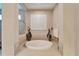 Large soaking tub in the bathroom with tile surround and plantation shutters at 2903 Marble Crest Dr, Land O Lakes, FL 34638